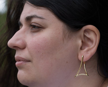 model wearing triangle hanging earrings