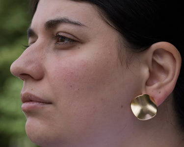model wearing twisted coin earrings